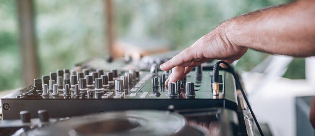 DJ steuert Mischpult draußen | Pavillon